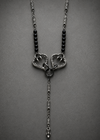 A gothic-style silver pendant necklace featuring two interlocking open hearts with sharp talons, flanked by black beads on a textured chain, set against a dark gray background.